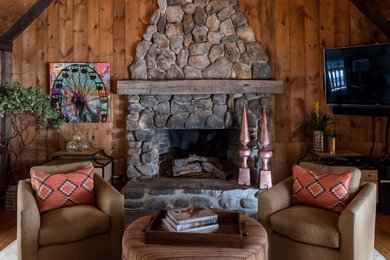 Example of a mountain style living room design in Portland Maine with a standard fireplace and a stone fireplace