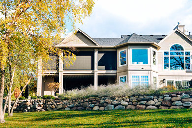 Huge elegant backyard ground level privacy and metal railing deck photo in Other with a roof extension