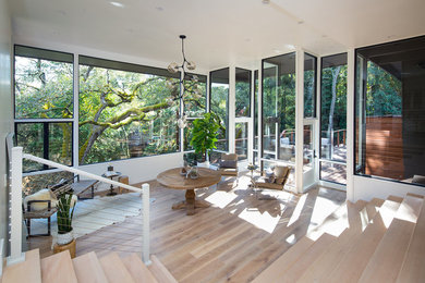 Huge 1960s light wood floor entryway photo in San Francisco with white walls and a glass front door