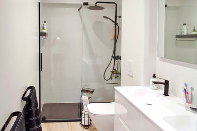 Ejemplo de cuarto de baño gris y negro contemporáneo con ducha abierta, baldosas y/o azulejos blancos, paredes blancas, suelo laminado, suelo beige, ducha abierta, encimeras blancas y cuarto de baño