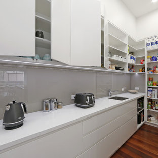 Imagen de cocina lineal, actual, con despensa, fregadero bajoencimera, armarios con paneles lisos, puertas de armario blancas y salpicadero verde