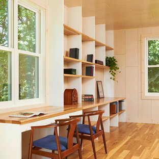 Photo of a modern home office and library in Minneapolis with beige walls, medium hardwood flooring and a built-in desk.