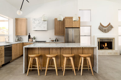 Inspiration for a scandinavian gray floor and vaulted ceiling kitchen remodel in Phoenix with flat-panel cabinets, medium tone wood cabinets, marble countertops, white backsplash, mosaic tile backsplash, stainless steel appliances, an island and gray countertops
