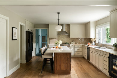 Transitional l-shaped medium tone wood floor eat-in kitchen photo in Burlington with an undermount sink, shaker cabinets, quartz countertops, green backsplash, ceramic backsplash, black appliances and an island