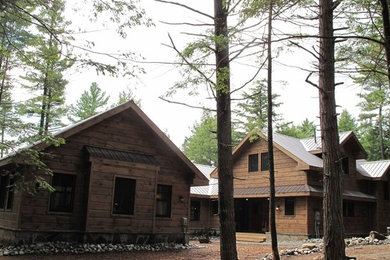 Inspiration for a large rustic brown two-story wood exterior home remodel in Toronto with a metal roof