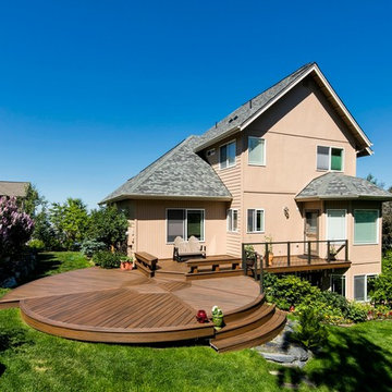 Round Trex deck with inlay, built in benches, and cable rail framed in aluminum