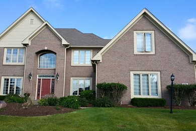 Inspiration for a large timeless red two-story brick exterior home remodel in Indianapolis