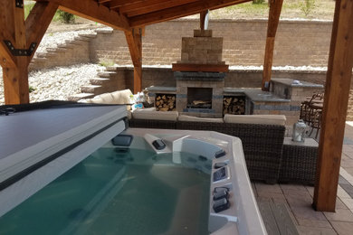 Inspiration for a large 1960s backyard concrete paver patio remodel in Other with a fireplace