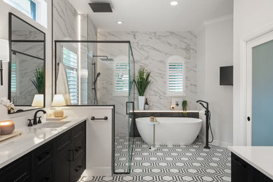 Example of a mid-sized transitional master white tile and porcelain tile mosaic tile floor, multicolored floor and double-sink bathroom design in Orlando with raised-panel cabinets, black cabinets, a one-piece toilet, white walls, a drop-in sink, quartz countertops, a hinged shower door, white countertops, a niche and a floating vanity