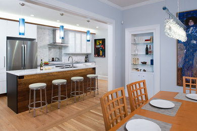 Inspiration for a small contemporary galley light wood floor eat-in kitchen remodel in Other with an undermount sink, flat-panel cabinets, white cabinets, quartz countertops, gray backsplash, marble backsplash, stainless steel appliances, an island and gray countertops