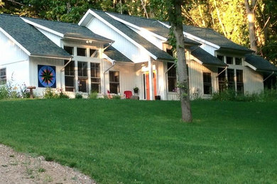 Large traditional white one-story vinyl exterior home idea in Grand Rapids with a shed roof