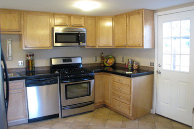 Eat-in kitchen - traditional l-shaped eat-in kitchen idea in Denver with a drop-in sink, raised-panel cabinets, brown cabinets, granite countertops, beige backsplash, mosaic tile backsplash and stainless steel appliances