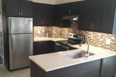 Eat-in kitchen - small traditional u-shaped vinyl floor eat-in kitchen idea in Toronto with an undermount sink, flat-panel cabinets, dark wood cabinets, quartz countertops, multicolored backsplash, mosaic tile backsplash, stainless steel appliances and a peninsula