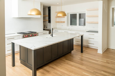 Inspiration for a large modern u-shaped open plan kitchen in Chicago with an undermount sink, shaker cabinets, white cabinets, marble benchtops, white splashback, stainless steel appliances, light hardwood floors, with island, beige floor and white benchtop.