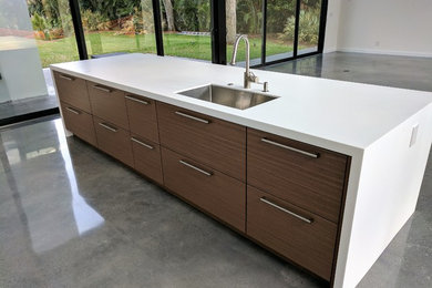 Example of a large minimalist kitchen design in Miami with solid surface countertops
