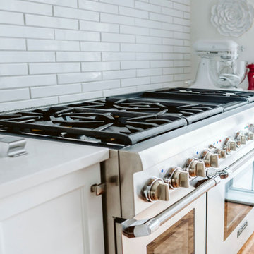 Stainless steel gas stove, white ceramic backsplash