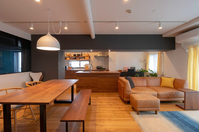 Example of a mid-sized trendy medium tone wood floor and brown floor great room design in Tokyo with white walls