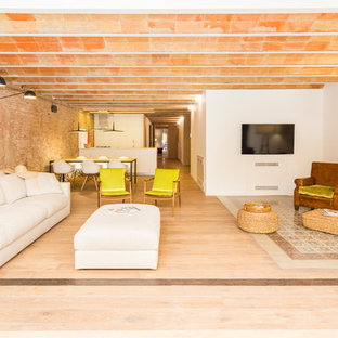 Immagine di un grande soggiorno mediterraneo aperto con pareti bianche, parquet chiaro, TV a parete e pavimento viola