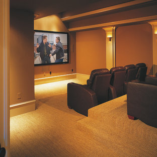 Inspiration for a large timeless enclosed carpeted home theater remodel in Charleston with brown walls and a projector screen