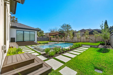 Pool landscaping - large modern backyard rectangular infinity pool landscaping idea in Houston