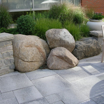 Stone Clad Walls Interrupted by Local Granite Boulders and Perennials