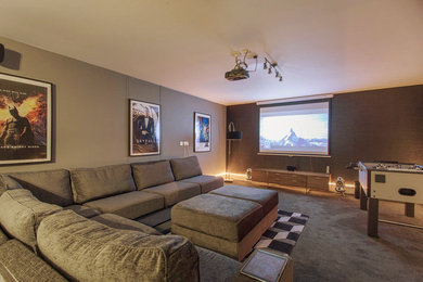 This is an example of a large eclectic home theatre in London with grey walls, carpet, a projector screen and grey floor.