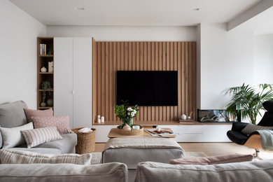 Imagen de salón abierto y blanco y madera minimalista de tamaño medio con paredes blancas, suelo laminado, chimenea lineal, marco de chimenea de yeso, suelo marrón y panelado
