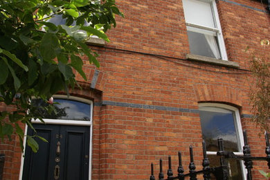 Inspiration for a contemporary two-storey brick red exterior in Dublin with a gable roof.