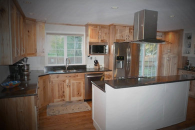 Example of a large mountain style u-shaped medium tone wood floor and brown floor eat-in kitchen design in Seattle with a double-bowl sink, shaker cabinets, light wood cabinets, granite countertops, stainless steel appliances and an island