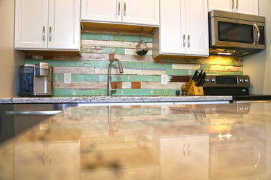 Example of a large transitional u-shaped porcelain tile kitchen design in Miami with an undermount sink, shaker cabinets, white cabinets, granite countertops, green backsplash, stainless steel appliances and an island