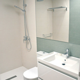 Ispirazione per una piccola stanza da bagno padronale minimalista con ante lisce, ante bianche, pavimento in bambù, lavabo sospeso, top in superficie solida e porta doccia scorrevole