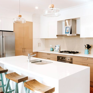 Mid-sized contemporary kitchen pantry inspiration - Kitchen pantry - mid-sized contemporary galley medium tone wood floor and brown floor kitchen pantry idea in Wollongong with a drop-in sink, flat-panel cabinets, white cabinets, beige backsplash, mosaic tile backsplash, stainless steel appliances, an island and white countertops