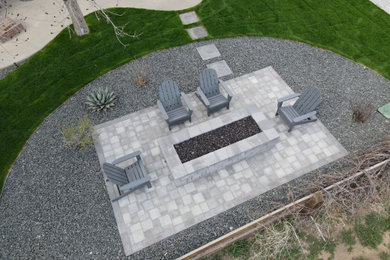 Diseño de patio minimalista grande sin cubierta en patio trasero con brasero y adoquines de hormigón