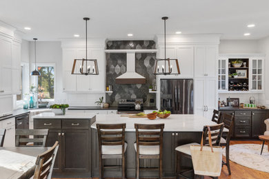 Inspiration for a transitional medium tone wood floor kitchen remodel in Minneapolis with a farmhouse sink, flat-panel cabinets, dark wood cabinets, quartz countertops, stainless steel appliances, an island and white countertops