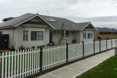 Photo of a mid-sized traditional one-storey white exterior in Melbourne with concrete fiberboard siding and a gable roof.
