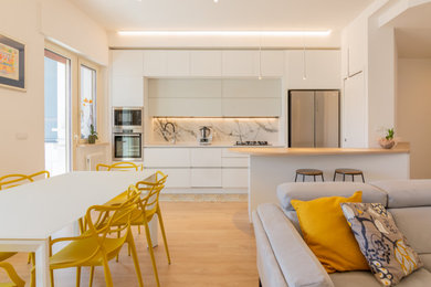 Immagine di una grande sala da pranzo aperta verso il soggiorno design con pareti bianche, parquet chiaro e pavimento beige
