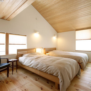 Foto di una camera da letto etnica con pareti bianche e parquet chiaro