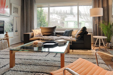 Inspiration for a mid-sized contemporary open concept laminate floor and brown floor living room remodel in Seattle with gray walls, a stone fireplace and a wall-mounted tv