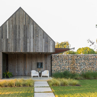 ダラスのラスティックスタイルのおしゃれな住宅の外観 (木材サイディング、茶色い外壁、切妻屋根) の写真