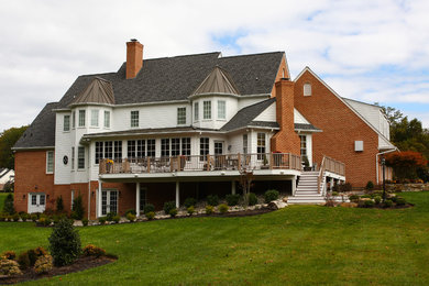Example of a huge classic white three-story brick exterior home design in Baltimore with a mixed material roof