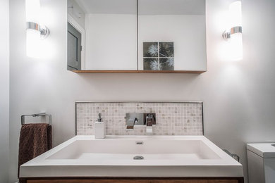 Bathroom - small modern master gray tile and marble tile ceramic tile and gray floor bathroom idea in Montreal with flat-panel cabinets, brown cabinets, a one-piece toilet, gray walls, a drop-in sink, quartz countertops and white countertops