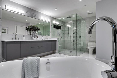 Inspiration for a contemporary white tile and stone tile porcelain tile bathroom remodel in Vancouver with flat-panel cabinets, gray cabinets, a one-piece toilet, gray walls, an undermount sink and quartz countertops