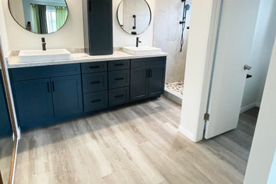 Example of a large classic master beige tile and ceramic tile vinyl floor, beige floor and double-sink bathroom design in San Diego with shaker cabinets, blue cabinets, a two-piece toilet, white walls, a vessel sink, quartz countertops, beige countertops and a built-in vanity
