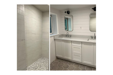 Example of a mid-sized transitional white tile and marble tile porcelain tile, gray floor, double-sink and shiplap wall alcove shower design in New York with shaker cabinets, white cabinets, a two-piece toilet, a drop-in sink, marble countertops, a hinged shower door, gray countertops and a built-in vanity