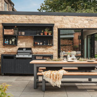 Inspiration for a large farmhouse back patio in Gloucestershire with an outdoor kitchen and natural stone paving.