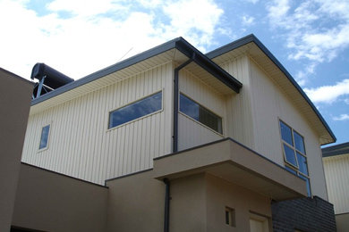 This is an example of a modern beige exterior in Melbourne with vinyl siding.