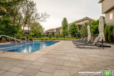 This is an example of a large traditional partial sun backyard concrete paver retaining wall landscape in Omaha for summer.