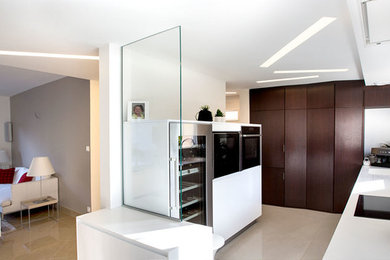 Photo of a small contemporary u-shaped open plan kitchen in Angers with an integrated sink, beaded inset cabinets, solid surface benchtops, glass sheet splashback, stainless steel appliances and ceramic floors.