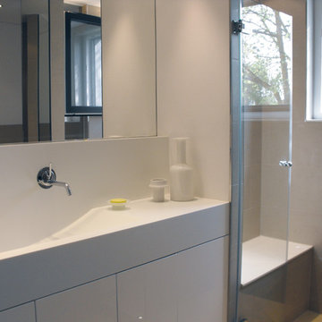 Waschtisch und Sitzbank in der Dusche aus Mineralwerktoff. Duchtüre ESG klar