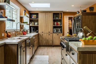 Photo of a mid-sized arts and crafts l-shaped kitchen in Portland Maine with flat-panel cabinets, stainless steel cabinets, concrete benchtops, stainless steel appliances, light hardwood floors and with island.